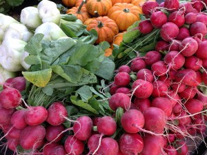 radishes and pumpkins on table at farmers market
