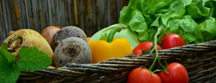 fresh tomatoes, peppers, and other vegetables in a basket