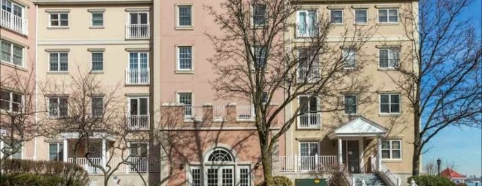 A peach-colored condo unit nestled between two smaller townhomes in Port Liberte.